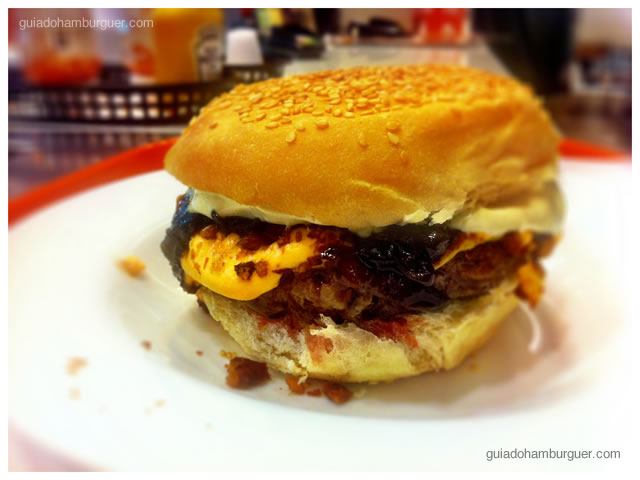 Hambúrguer bovino, queijo cheddar, bacon, picles, chutney de cebola roxa, maionese tradicional e maionese de wasabi
