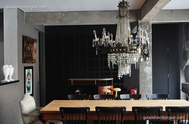 Salão com grande lustre e mesa para dez pessoas