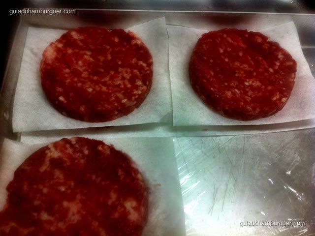 Hambúrgueres na bandeja prontos para serem grelhados