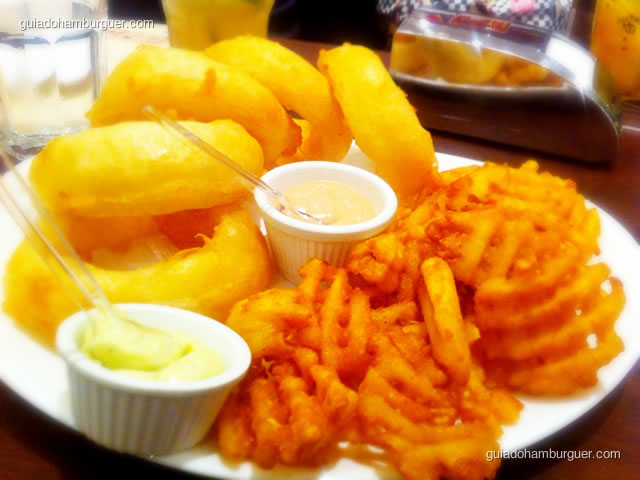 Porção meio a meio de batatas waffles e onion rings