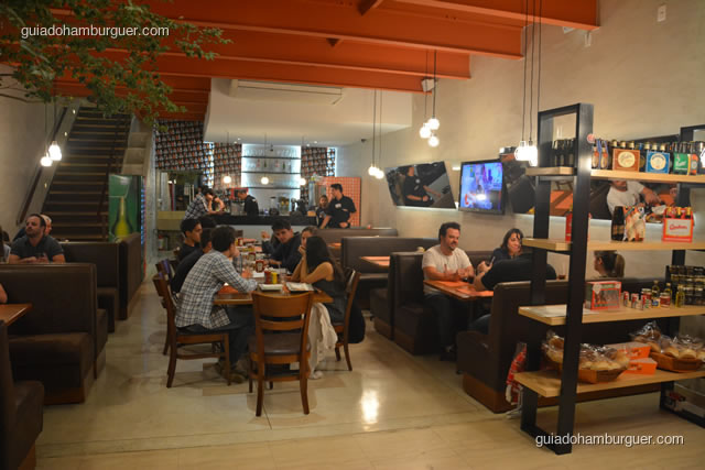 Ambiente com os sofás na laterais e mesas ao centro - Burger Lab Experience