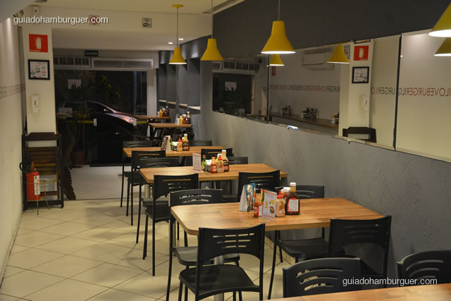 Ambiente com mesas e cadeiras visto de dentro - I Love Burger