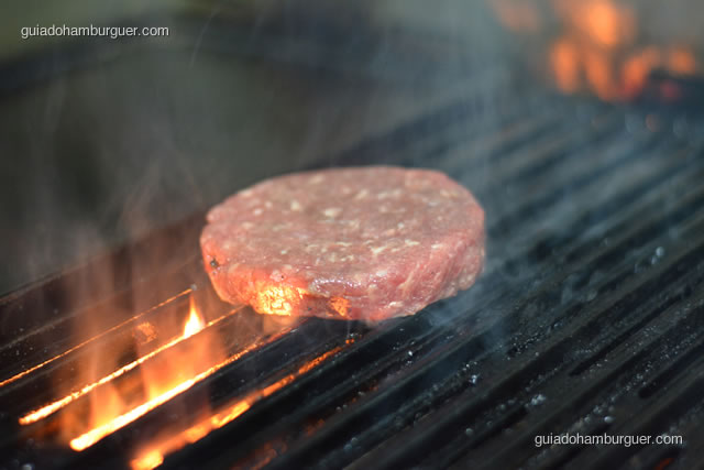 Hambúrguer sendo selado no fogo - Hamburgueria 162 Express