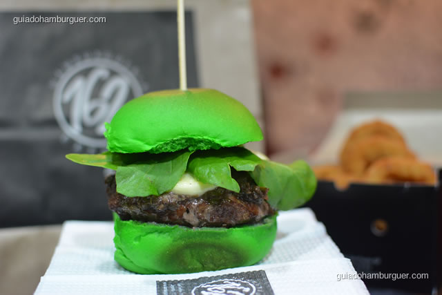 Italianinho: pão de hambúrguer de abacate, hambúrguer artesanal bovino, tepanade de azeitonas pretas, mussarela de búfala e rúvula ao pesto. - Hamburgueria 162 Express