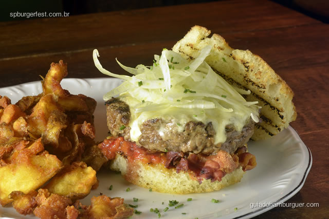 Botta Burger - Hambúrguer de 190g de carne tenra e suculenta assado no forno à lenha e coberto com mussarela especial, cubos de pancetta, tiras de finocchio e pasta de peperoncino Bottagallo, no nosso pão focaccia caseiro. Acompanha um punhado de batatas rústicas. - SP Burger Fest 3ª edição