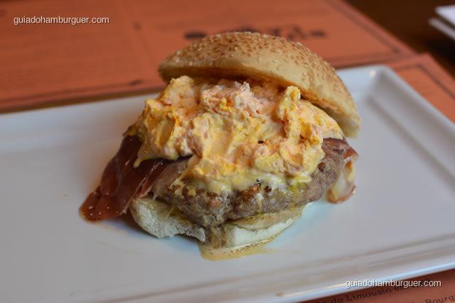 Andalucia:hHambúrguer de Ribeye Black Angus Reserva (200 gramas), pão clássico de hambúrguer com gergelim, presunto pata negra, queijo Serra da Estrela, sour cream de açafrão Iraniano - Burger Lab Experience