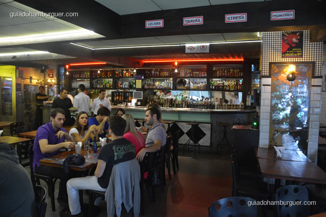 Ambiente com o bar ao fundo - La Maison Est Tombeé