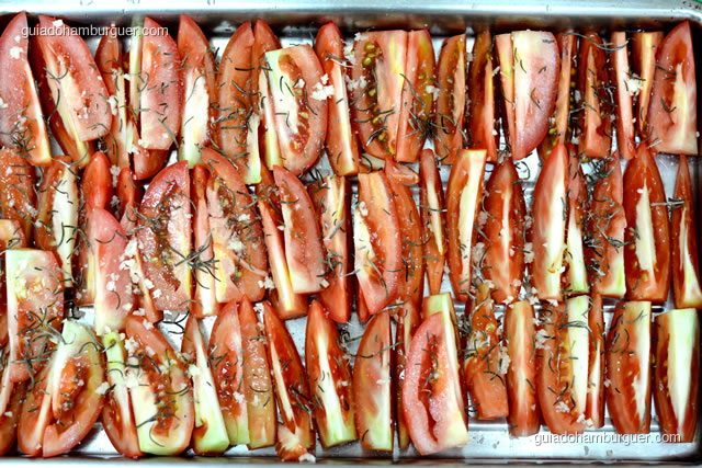 Coloque os tomates na bandeja e tempere