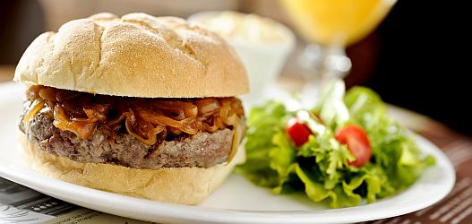 USA Burger com hambúrguer de picanha, sweet onion sauce acompanhado de saladinha de repolho, a coleslaw. O pão é do tipo caseiro feito de farinhas de trigo, fubá e pimenta rosa. - General Prime Burger